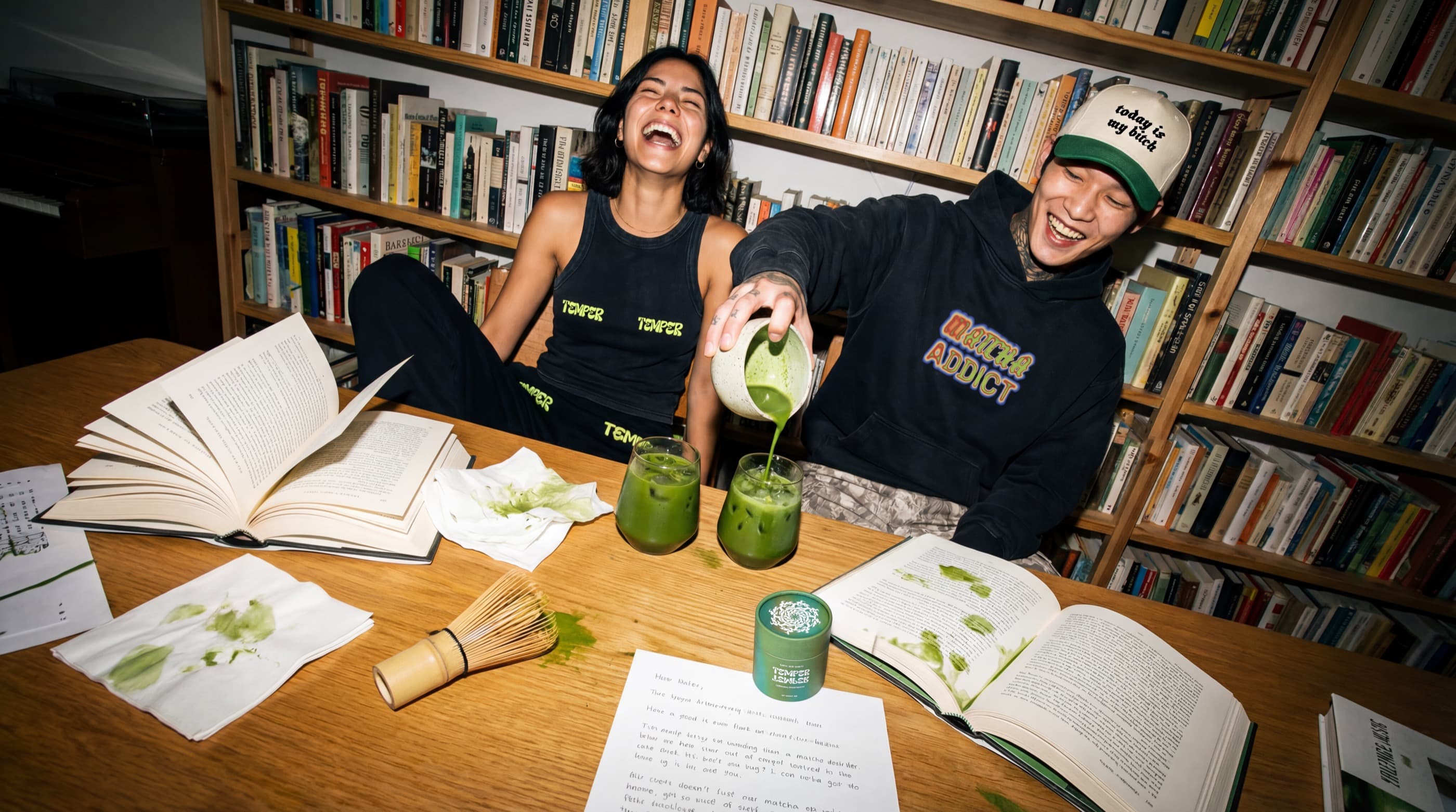 Two people laughing over matcha in a library